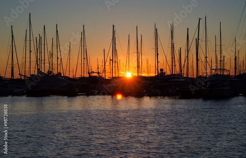 Montenegro's harbor on sunset, silhouettes of sailboat  in the p