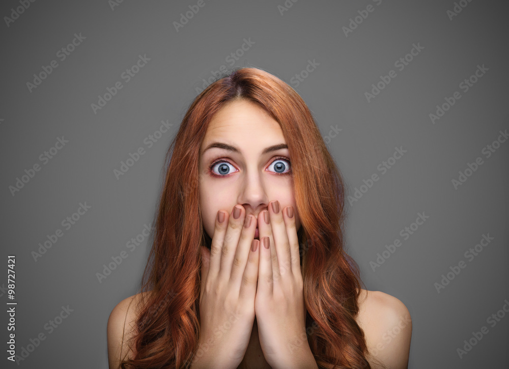 Girl covering her mouth with hands, isolated on gray. Girl covering her mouth with hands, isolated on gray.