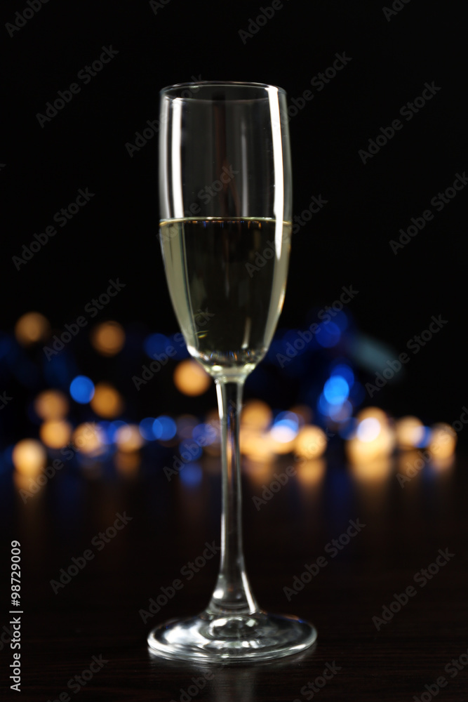 A glass of champagne with bokeh on dark background A glass of champagne with bokeh on dark background