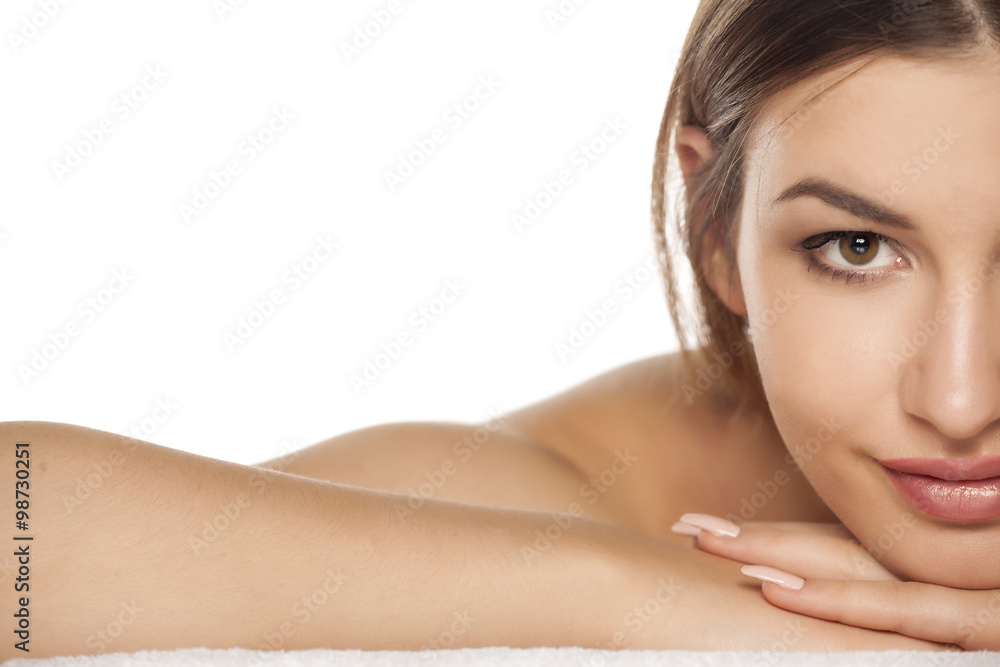 half portrait of a smiling young woman is lying down on towel half portrait of a smiling young woman is lying down on towel