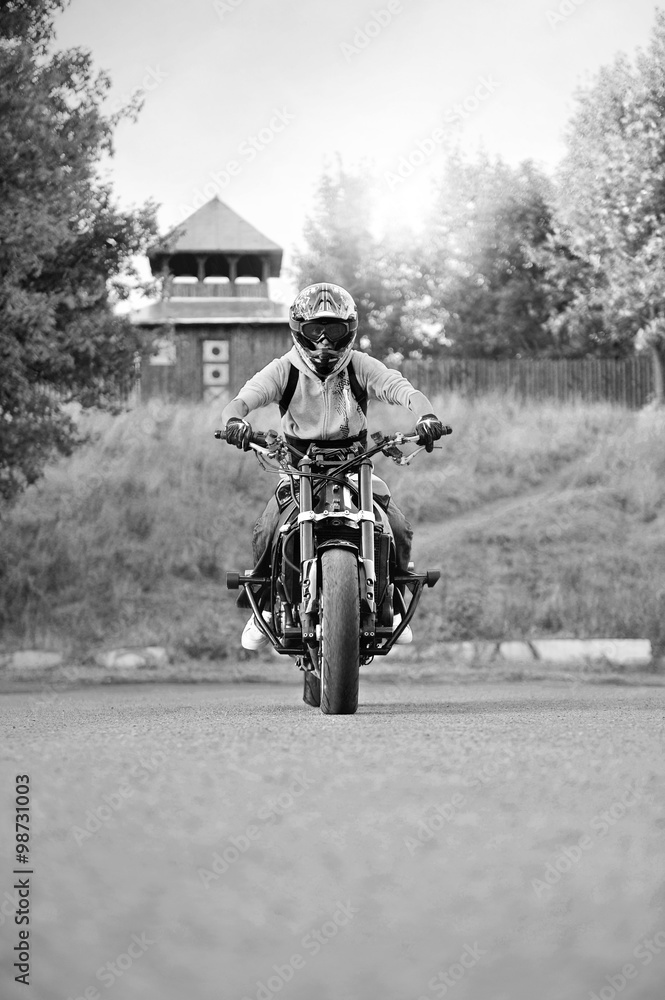 Wrroom-wrroom. Monochrome soft smudged focus shot of a biker in a helmet read to start racing