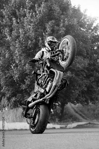 Living to stunt. Black and white soft smudged focus portrait of a male biker practicing free style tricks on a bike