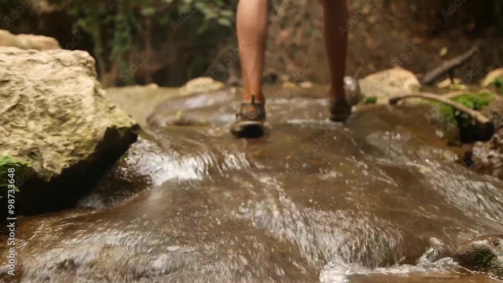 Man walks in the creek in sandals. Man walks in the creek in sandals.