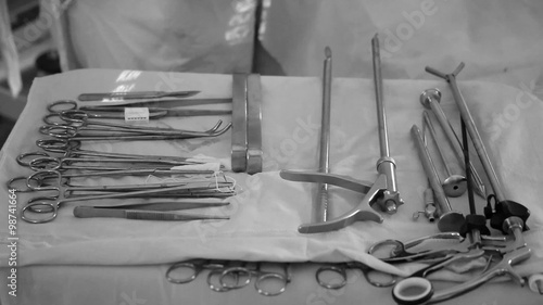 Steel surgical instruments on a sterile white cloth