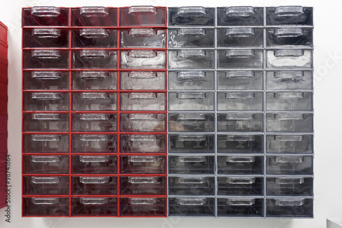 Small parts plastic box in red and gray, complete with sixty empty, transparent drawers and dividers.