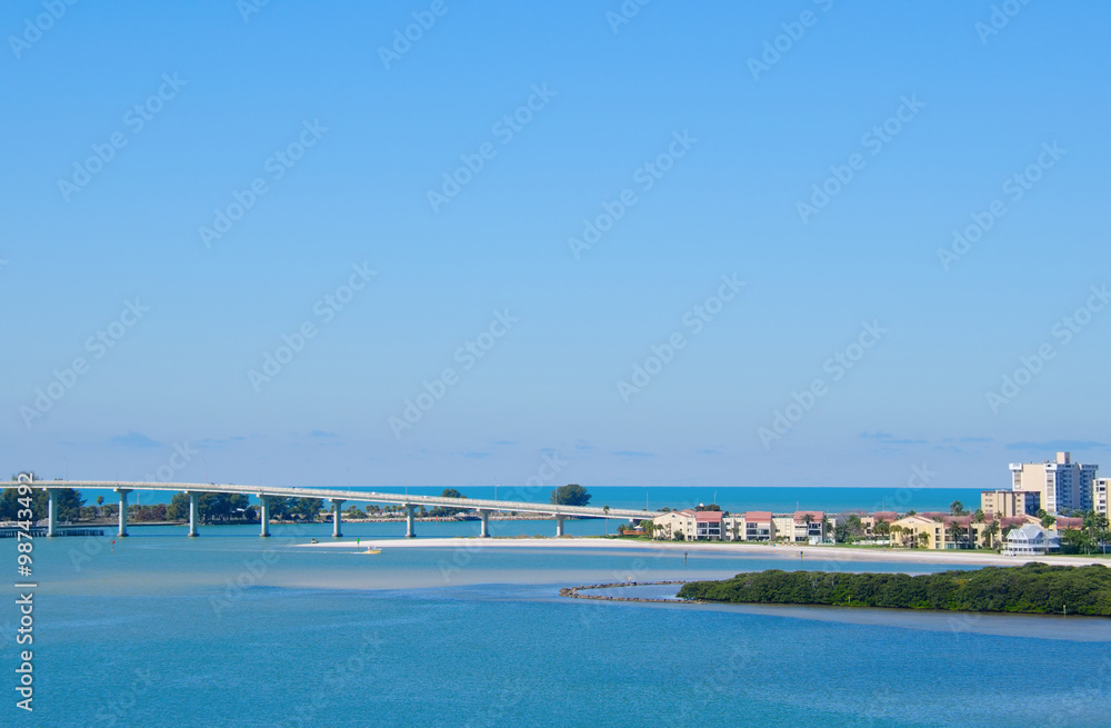 Sand Key Bridge in Clearwater Beach, Florida which crosses Clearwater Pass that leads out to the Gulf of Mexico on a beautiful sunny morning with clear blue skies.