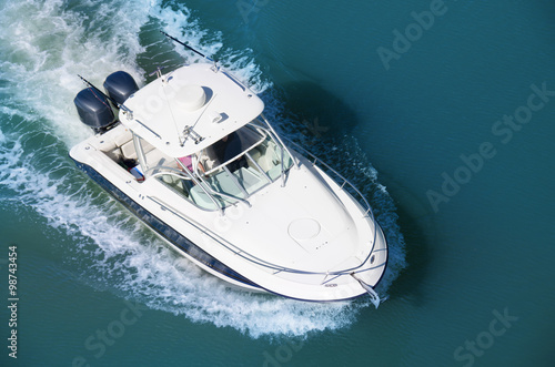 Aerial photograph of a motor boat with two motors cruising through blue water