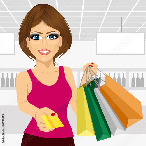 young woman holding shopping bags and giving a credit card
