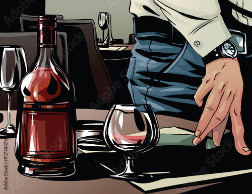 Elegant man's hand next to a glass of brandy