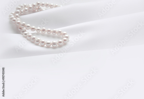 Elegant white background with silk and pearl
