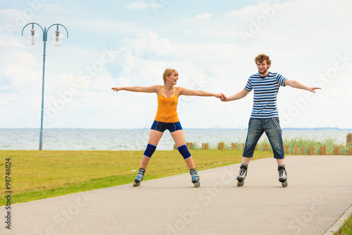 Young couple on roller skates riding outdoors