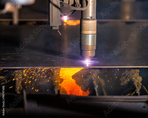 CNC Plasma torch cutting steelplate with red sparks