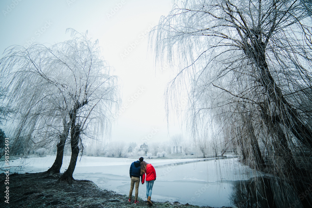 beautiful couple posing near a frozen river beautiful couple posing near a frozen river