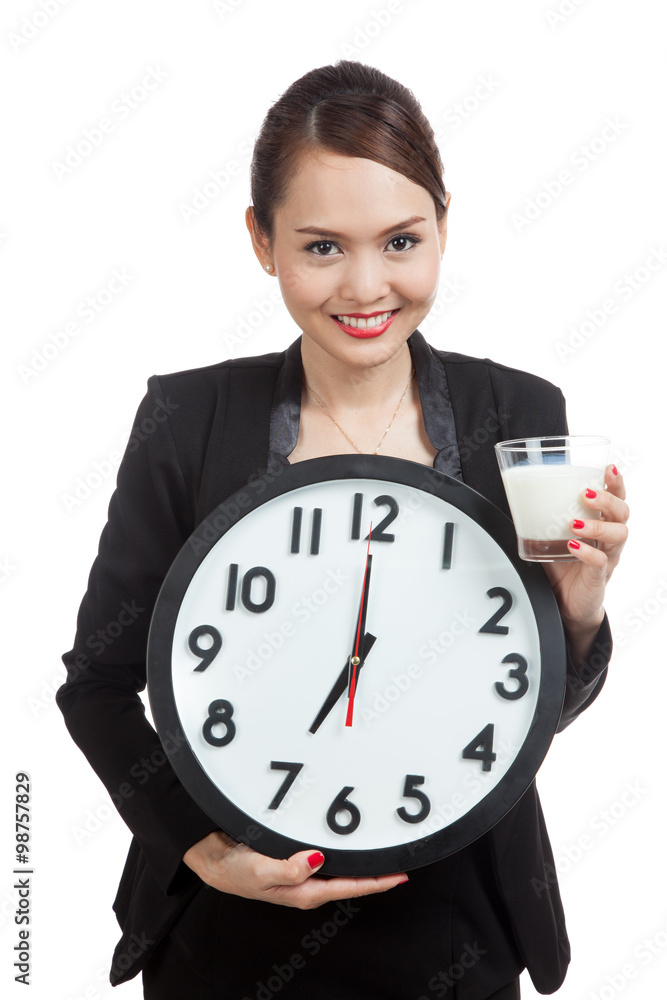 Healthy Asian woman drinking glass of milk hold clock Healthy Asian woman drinking glass of milk hold clock