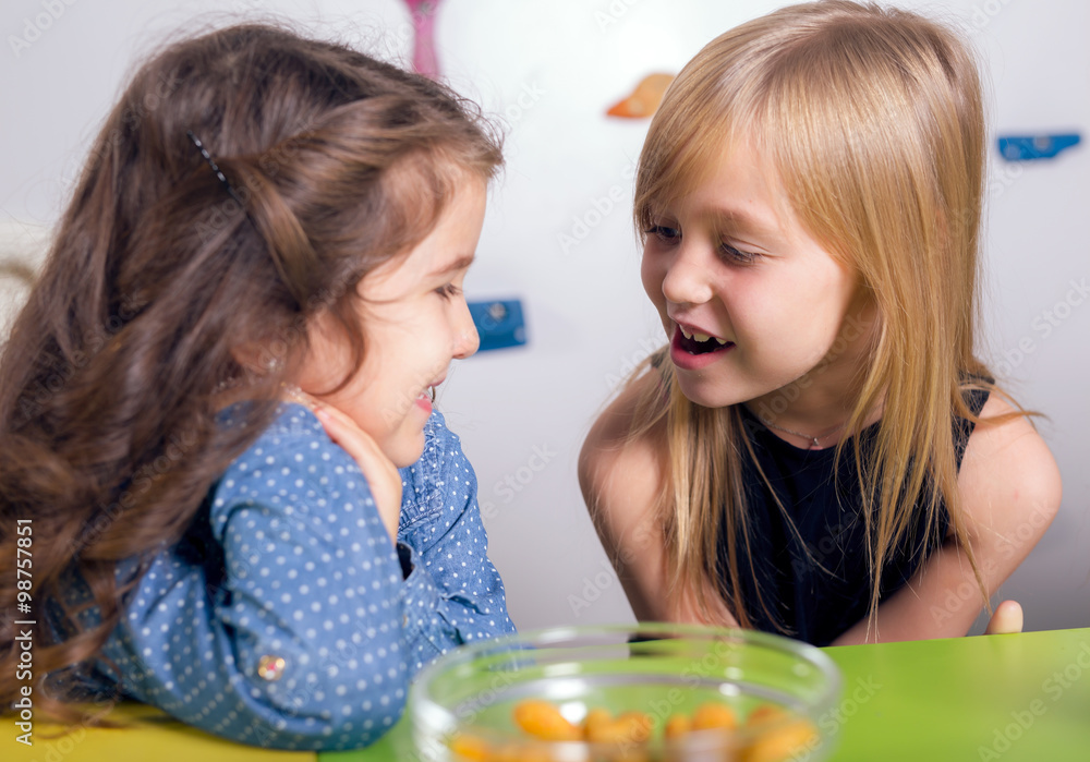 Little girls sitting and talking in the playroom Little girls sitting and talking in the playroom