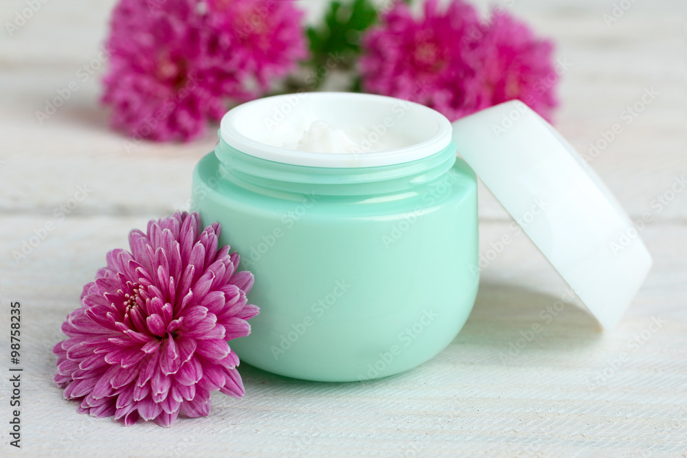 outdoor facial cream with chrysanthemum on wooden background outdoor facial cream with chrysanthemum on wooden background