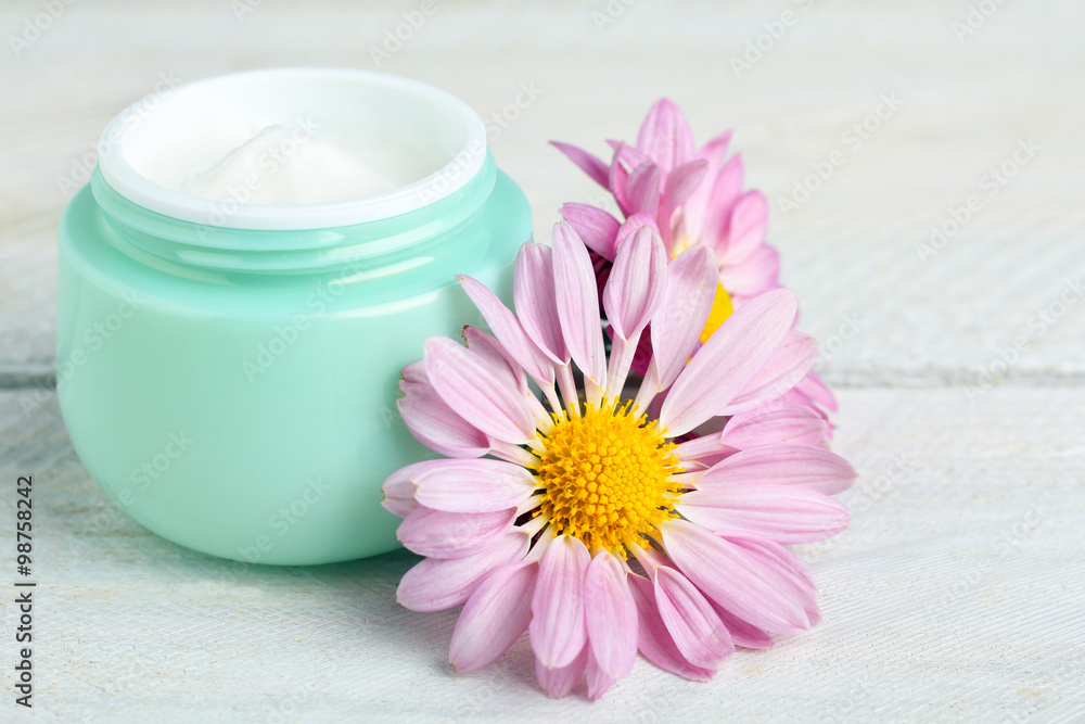 outdoor facial cream with chrysanthemum on wooden background outdoor facial cream with chrysanthemum on wooden background