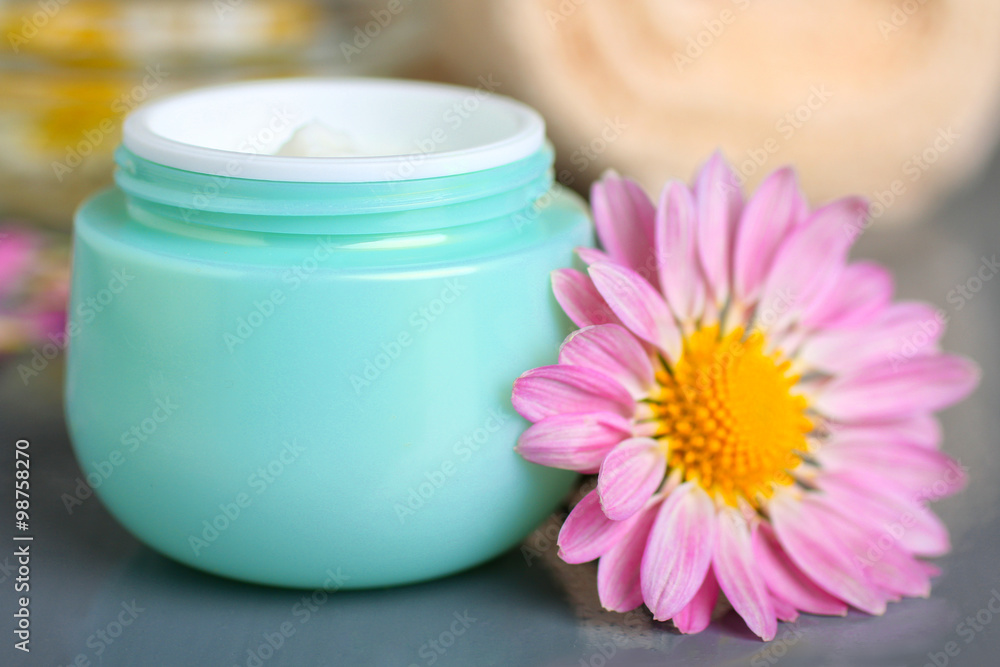 outdoor facial cream with chrysanthemum and towel on wooden background outdoor facial cream with chrysanthemum and towel on wooden background