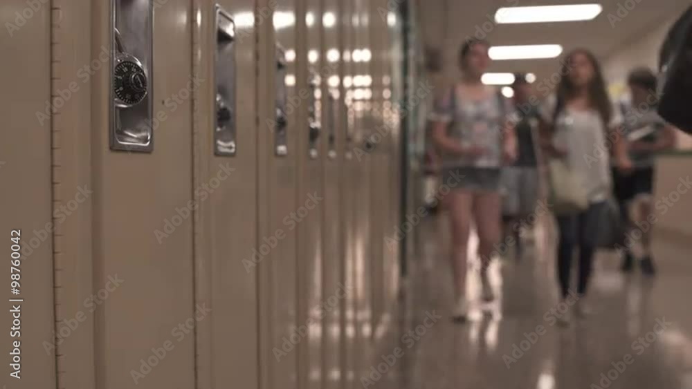 Students walking down hall by lockers Students walking down hall by lockers