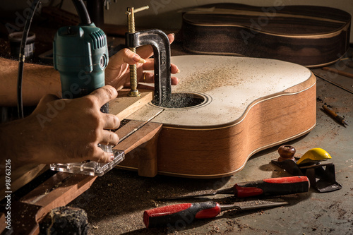 Luthier cutting a channel to place the truss rod in the guitar n photo