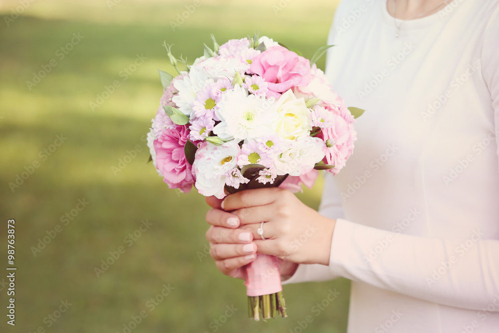 Beautiful wedding bouquet in hands of bride on nature background Beautiful wedding bouquet in hands of bride on nature background