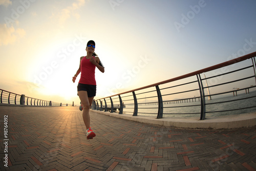 young fitness woman runner running at seaside