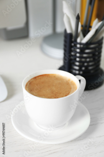Cup of coffee on workplace background
