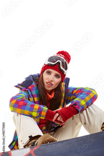Young woman sitting on floor with snowboard