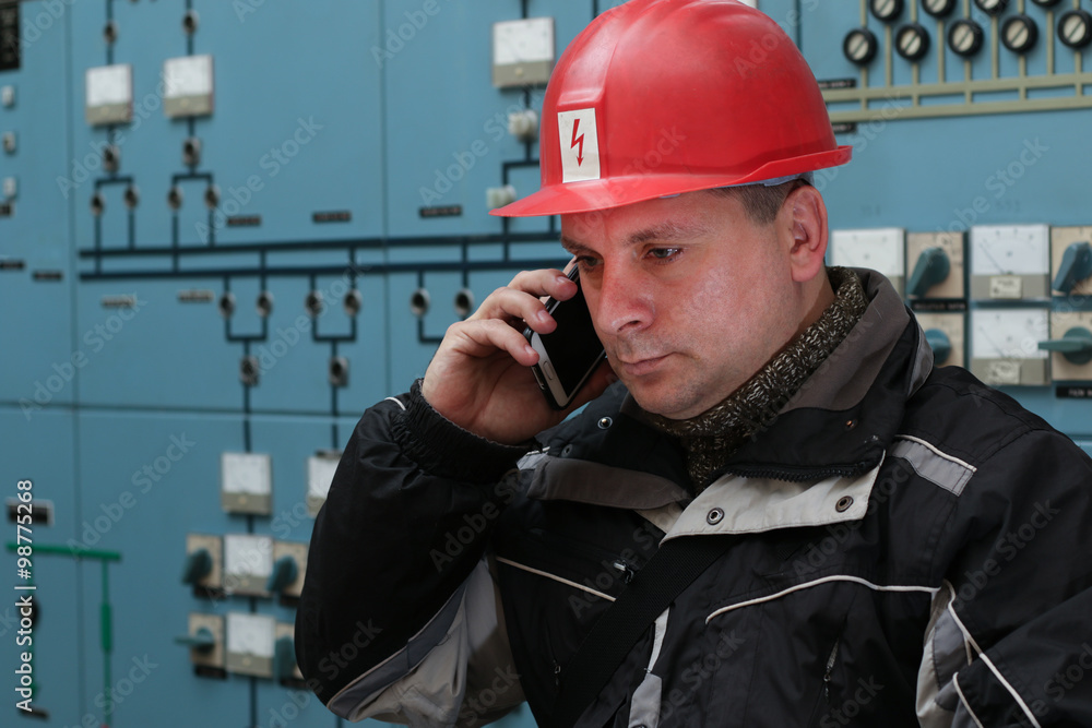 Technician make phone call in the power plant control center Technician make phone call in the power plant control center
