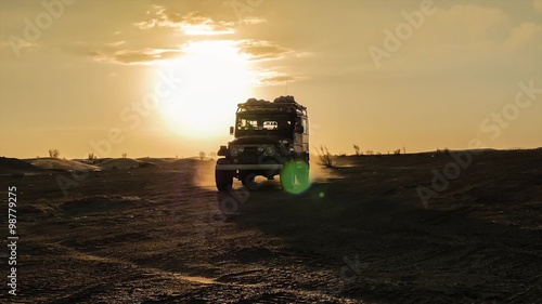 driving off-road car in the sahara desert at sunset
