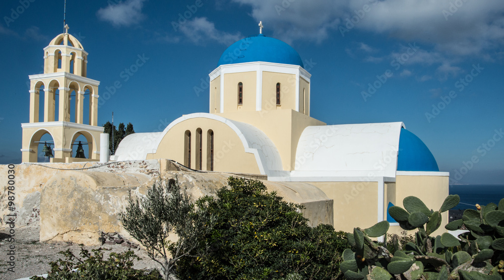 A Greek Orthodox church and bell tower in Oia town on the island of Santorini, Greece