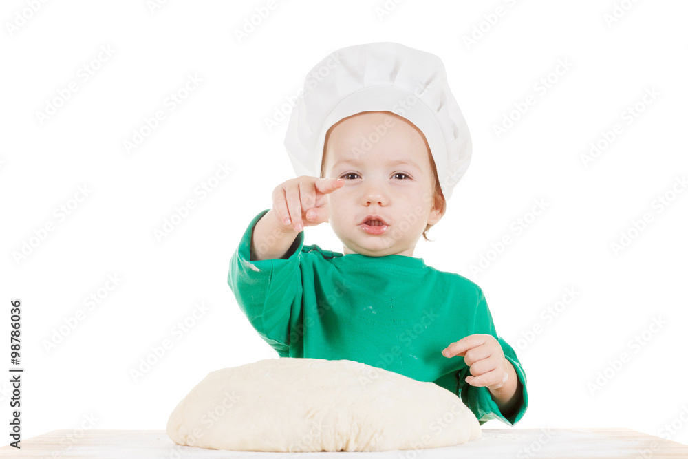 Serious little boy kneading dough for the cookies, isolated on white Serious little boy kneading dough for the cookies, isolated on white