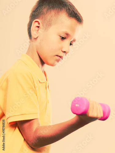 Sports boy making exercise with dumbbell.