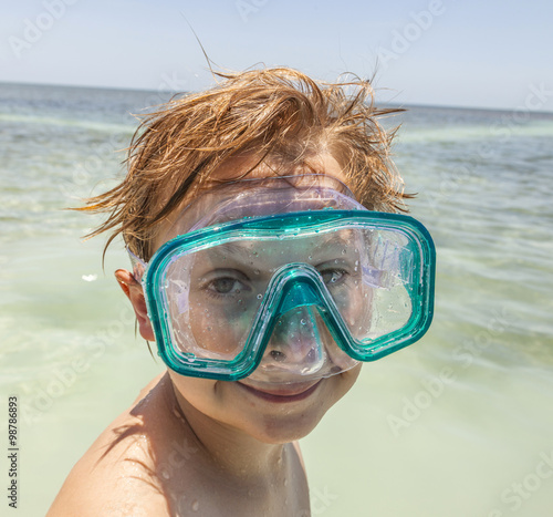 boy with diving mask enjoys the ocean photo