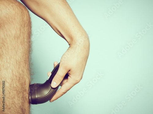 Caucasian man shaving hair from legs