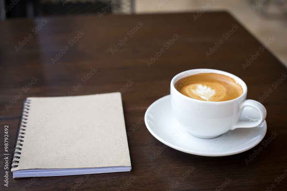 Coffee cup and notebook on grunge wooden background. Coffee cup and notebook on grunge wooden background.