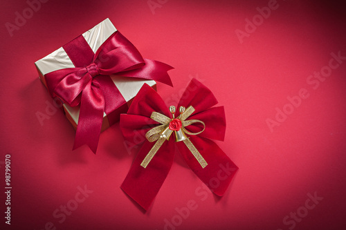 Christmas bow present box on red background holidays concept