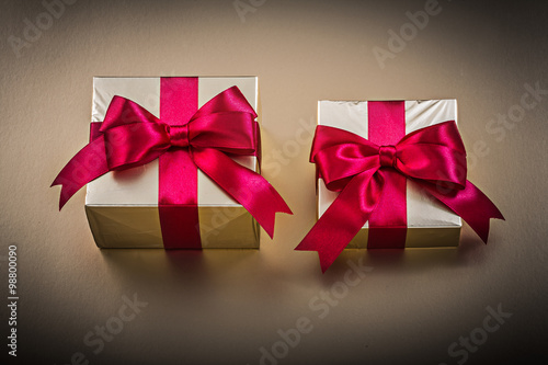 Gift boxes with tied ribbons on golden surface holidays concept