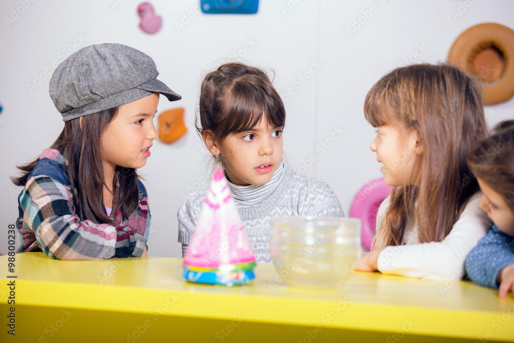 Fototapeta premium Little girls sitting and talking in the playroom