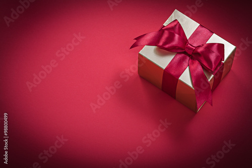 Present box on red background holidays concept
