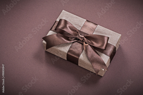 Wrapped present box on brown background holidays concept