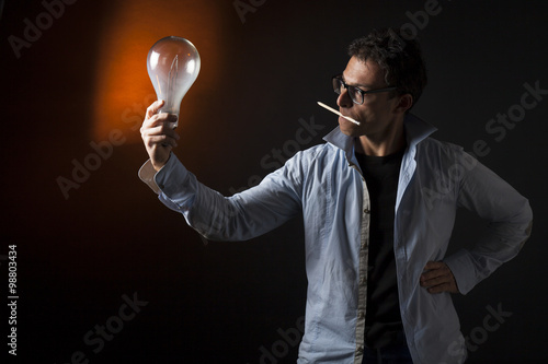 Concetto di studio, genialità, motivazione , lavoro: uomo d'affari tiene una lampada in mano photo