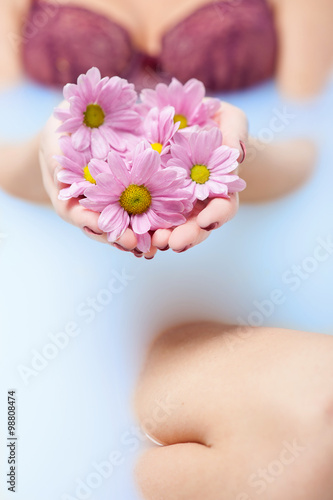 Cute young woman is having a herbal bath