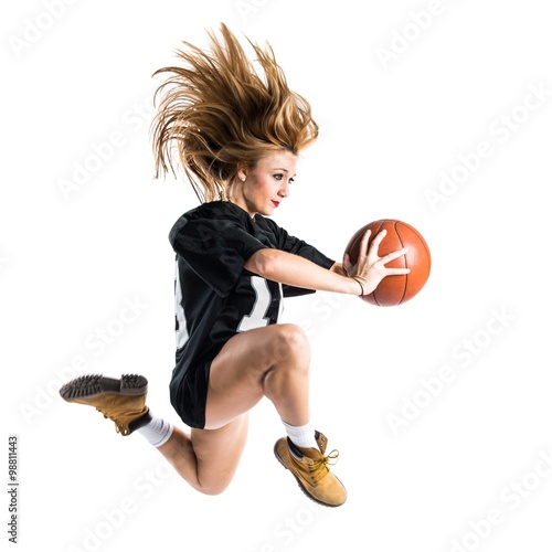 Woman jumping and playing basketball