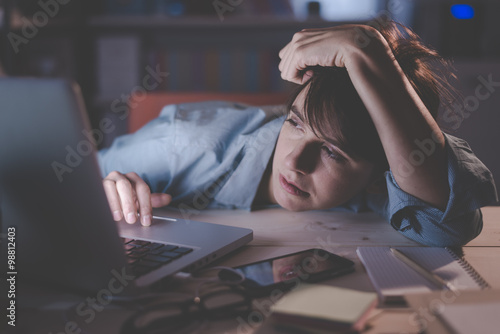 Sleepy woman working with her laptop