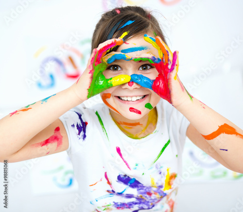 Cute girl playing with paints