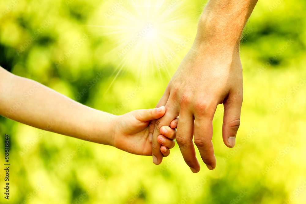 Hands of father and son holding each other Hands of father and son holding each other