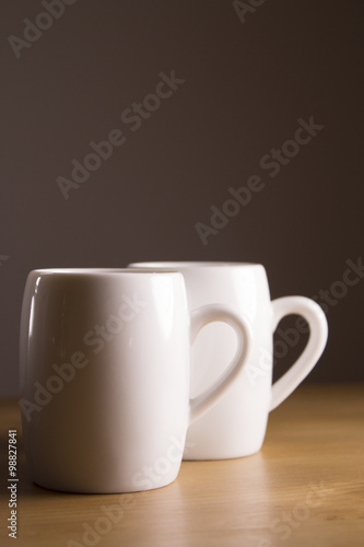 Two white coffee cup on wooden table.
