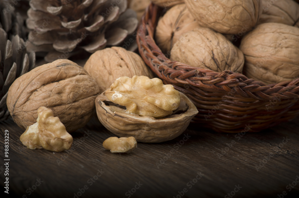 Walnut kernels and whole walnuts on rustic old wooden table Walnut kernels and whole walnuts on rustic old wooden table