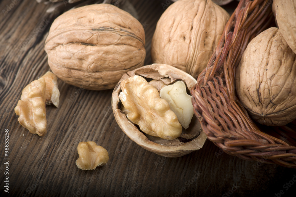 Walnut kernels and whole walnuts on rustic old wooden table Walnut kernels and whole walnuts on rustic old wooden table